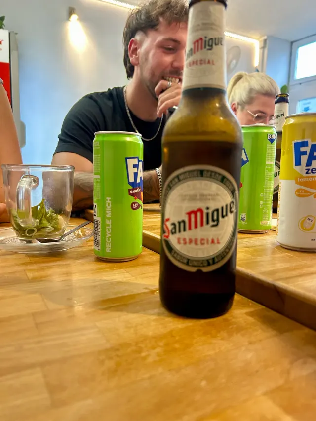 BookNoFees: 스낵바 – Good morning Vietnam – Aachen – San Miguel Especial 병과 Fanta 캔이 놓인 테이블입니다., 사진 2