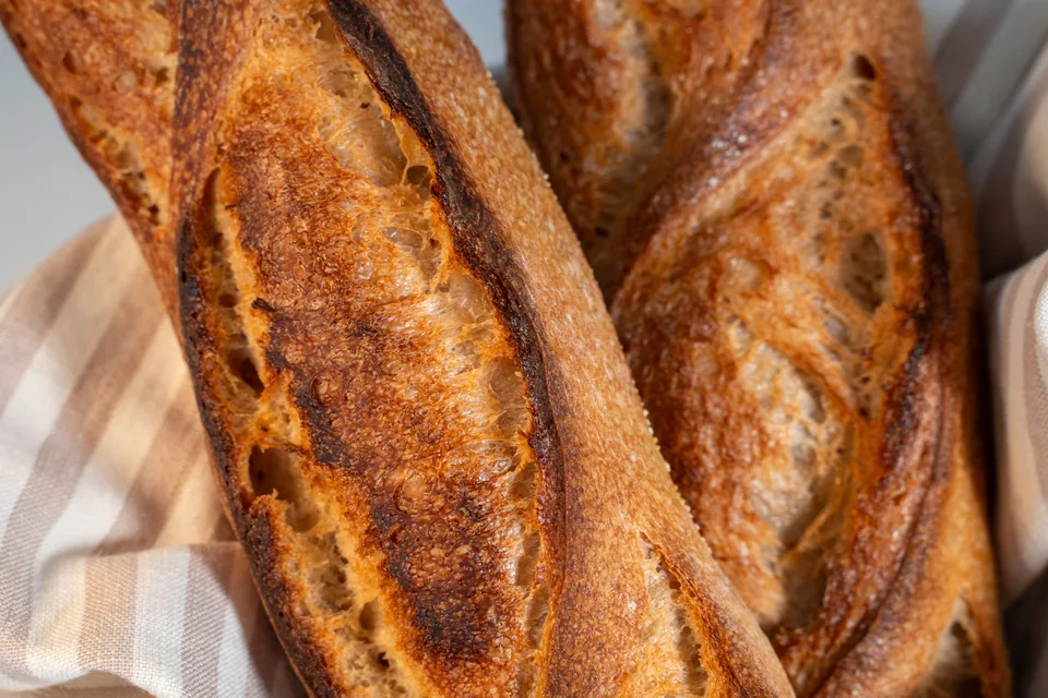 예시 사진: 체크무늬 천 위에 놓인 황금빛 바게트